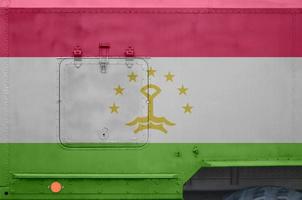 Tajikistan flag depicted on side part of military armored truck closeup. Army forces conceptual background photo