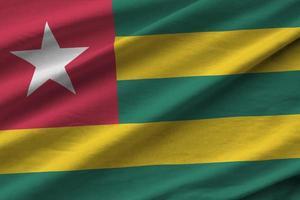 Togo flag with big folds waving close up under the studio light indoors. The official symbols and colors in banner photo