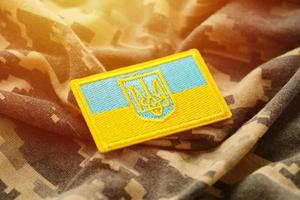 Military camouflage fabric with ukrainian flag on uniform chevron photo