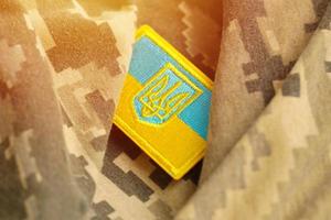 Military camouflage fabric with ukrainian flag on uniform chevron photo