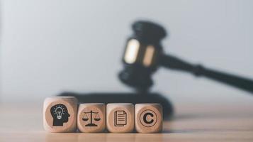 bloques de madera y mazo de juez de madera sobre la mesa, concepto de derechos de autor o propiedad intelectual protección de patentes de infracción de derechos de autor declaración de propiedad innovaciones legítimas foto
