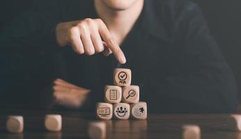 Businessman pointing at wooden block showing check icon, a quality check approval process concept, and a validation mark, a check mark symbol represents an international standard acceptance. photo