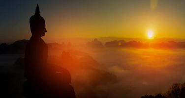 buddha silhouette on golden sunset background beliefs of Buddhism photo