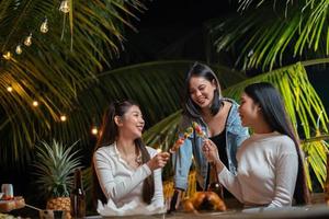 grupo de mujeres haciendo una barbacoa y divirtiéndose bebiendo cerveza en la fiesta. foto