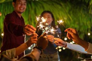 young party people holding sparkler in celebration photo