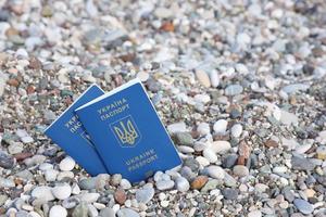 Two biometrical ukrainian passports on sea shore background photo