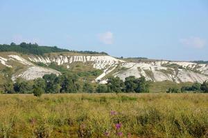 Ancient multimillion chalk mountains on the steppe surface of earth photo