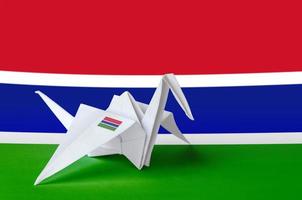 bandera de gambia representada en el ala de la grúa de origami de papel. concepto de artes hechas a mano foto