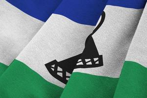 Lesotho flag with big folds waving close up under the studio light indoors. The official symbols and colors in banner photo