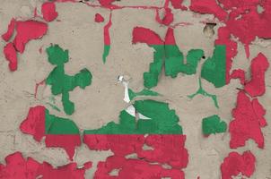 Maldives flag depicted in paint colors on old obsolete messy concrete wall closeup. Textured banner on rough background photo