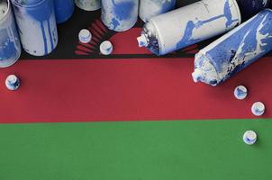 Malawi flag and few used aerosol spray cans for graffiti painting. Street art culture concept photo