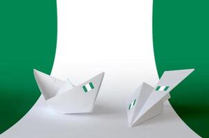 bandera de nigeria representada en avión y barco de origami de papel. concepto de artes hechas a mano foto