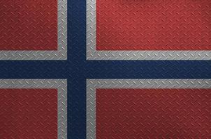 Norway flag depicted in paint colors on old brushed metal plate or wall closeup. Textured banner on rough background photo