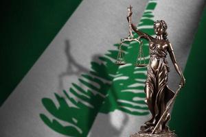 Norfolk island flag with statue of lady justice and judicial scales in dark room. Concept of judgement and punishment photo