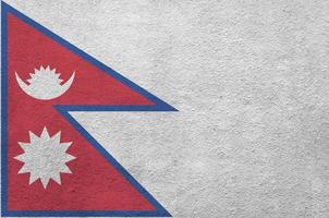 Nepal flag depicted in bright paint colors on old relief plastering wall. Textured banner on rough background photo