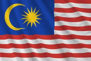 Malaysia flag with big folds waving close up under the studio light indoors. The official symbols and colors in banner photo