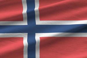 Norway flag with big folds waving close up under the studio light indoors. The official symbols and colors in banner photo