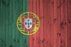 Portugal flag depicted in bright paint colors on old wooden wall. Textured banner on rough background photo