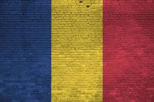 Romania flag depicted in paint colors on old brick wall. Textured banner on big brick wall masonry background photo