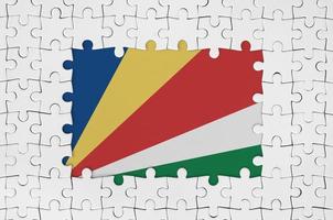 Seychelles flag in frame of white puzzle pieces with missing central part photo