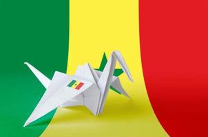 Senegal flag depicted on paper origami crane wing. Handmade arts concept