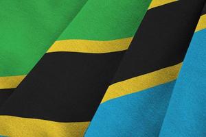 Tanzania flag with big folds waving close up under the studio light indoors. The official symbols and colors in banner photo