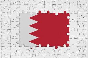 Bahrain flag in frame of white puzzle pieces with missing central part photo