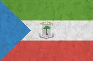 Equatorial Guinea flag depicted in bright paint colors on old relief plastering wall. Textured banner on rough background photo