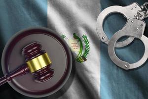 Guatemala flag with judge mallet and handcuffs in dark room. Concept of criminal and punishment, background for judgement topics photo