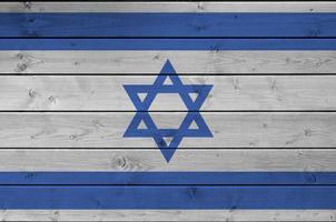 Israel flag depicted in bright paint colors on old wooden wall. Textured banner on rough background photo
