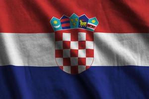 Croatia flag with big folds waving close up under the studio light indoors. The official symbols and colors in banner photo