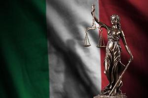 Italy flag with statue of lady justice and judicial scales in dark room. Concept of judgement and punishment photo