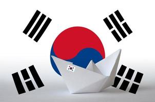 bandera de corea del sur representada en el primer barco de origami de papel. concepto de artes hechas a mano foto