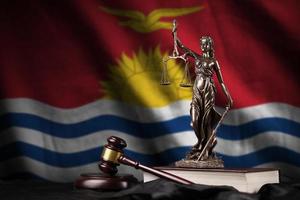 Kiribati flag with statue of lady justice, constitution and judge hammer on black drapery. Concept of judgement and guilt photo