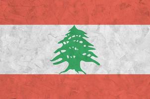 Lebanon flag depicted in bright paint colors on old relief plastering wall. Textured banner on rough background photo