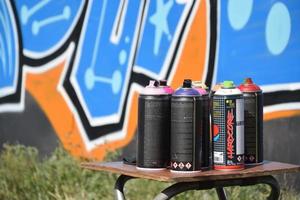 Used Montana black and hardcore aerosol spray cans against graffiti paintings. MTN or Montana-cans is manufacturer of high pressure spray paint goods photo