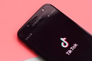 aplicación tiktok en la pantalla del teléfono inteligente samsung con fondo pastel. tiktok es un popular servicio de redes sociales para compartir videos propiedad de bytedance foto