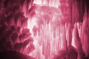 Huge ice icicles. Large blocks of ice frozen water. Blue ice background. Image toned in Viva Magenta, color of the 2023 year photo