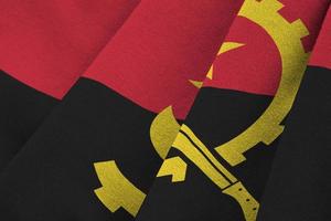 Angola flag with big folds waving close up under the studio light indoors. The official symbols and colors in banner photo