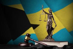 Bahamas flag with statue of lady justice, constitution and judge hammer on black drapery. Concept of judgement and guilt photo