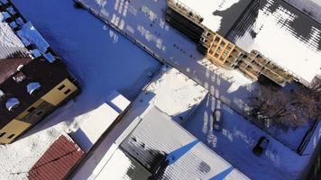 Fly over snowy streets by apartment buildings in Bakuriani ski town neighborhood video