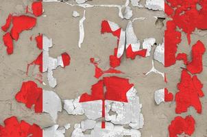 Canada flag depicted in paint colors on old obsolete messy concrete wall closeup. Textured banner on rough background photo