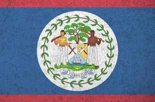 Belize flag depicted in bright paint colors on old relief plastering wall. Textured banner on rough background photo