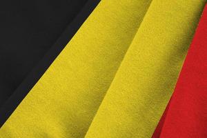 Belgium flag with big folds waving close up under the studio light indoors. The official symbols and colors in banner photo