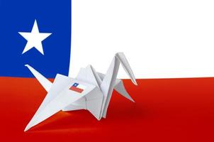 Chile flag depicted on paper origami crane wing. Handmade arts concept photo