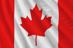 Canada flag with big folds waving close up under the studio light indoors. The official symbols and colors in banner photo