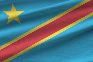 Democratic Republic of the Congo flag with big folds waving close up under the studio light indoors. The official symbols and colors in banner photo