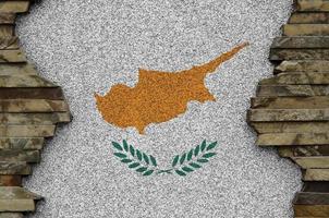 Cyprus flag depicted in paint colors on old stone wall closeup. Textured banner on rock wall background photo