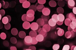 imagen de fondo abstracto con efecto bokeh. muchas imágenes de formas circulares brillantes tonificadas en magenta viva, color del año 2023 foto