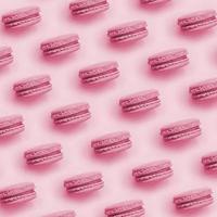 Dessert cake macaron or macaroon on trendy background top view. Flat lay pattern composition Image toned in Viva Magenta, color of the 2023 year photo